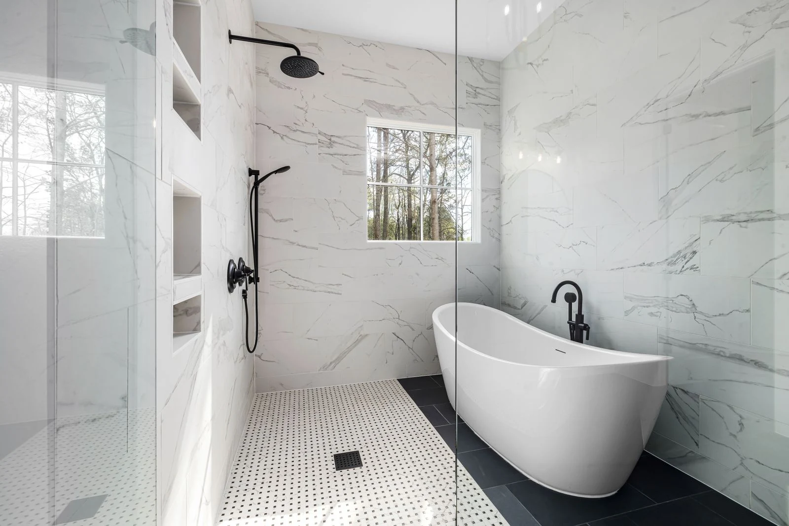 Sleek modern bathroom featuring a stylish freestanding bathtub and marble walls, perfect for luxury homes