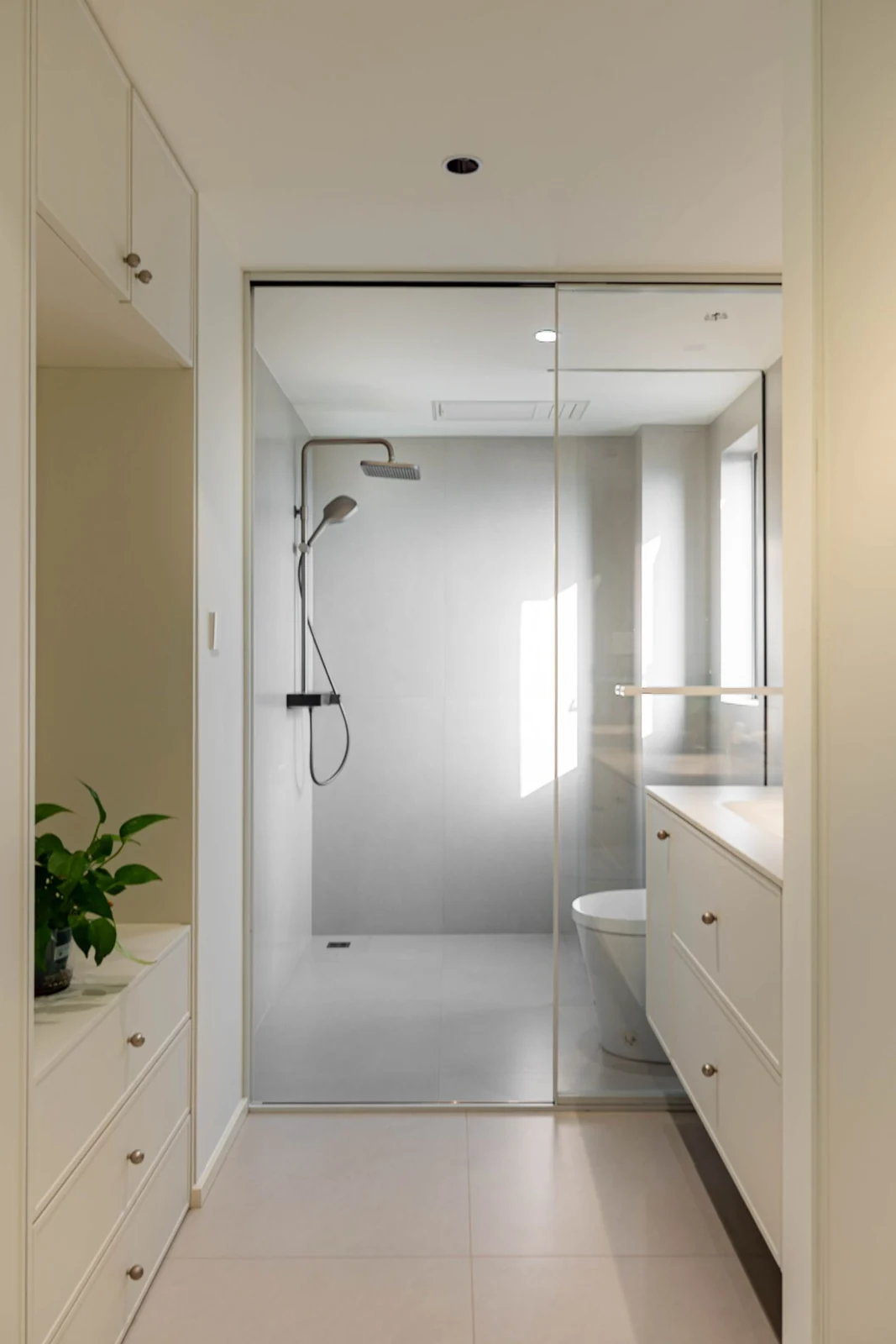 Bright and elegant modern bathroom with glass shower and sleek cabinetry