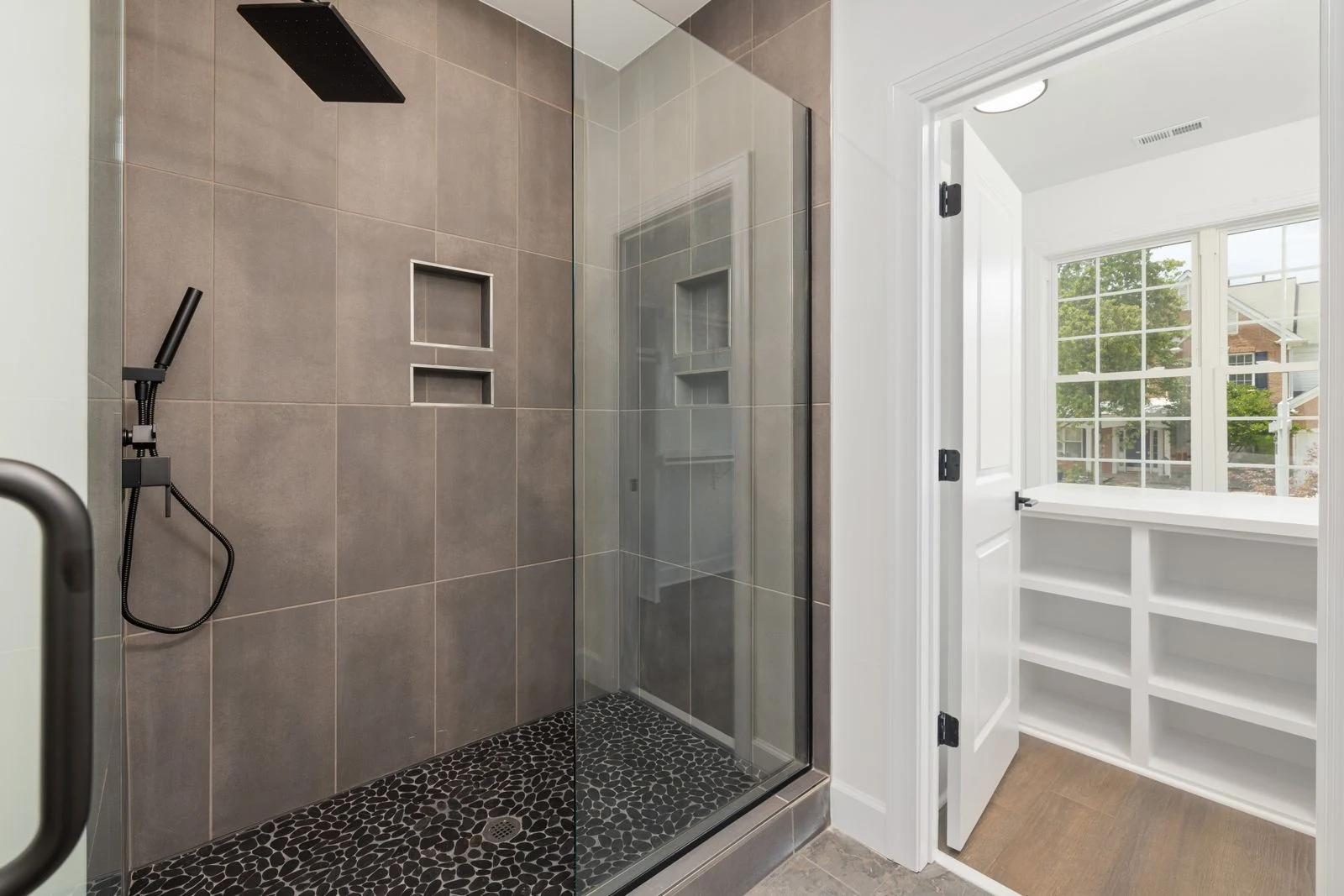 Stylish bathroom showcasing a glass-enclosed walk-in shower with a slate floor and tile walls