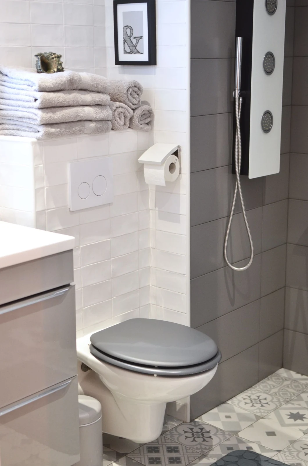 Elegant modern bathroom with tiled walls, shower, and compact toilet