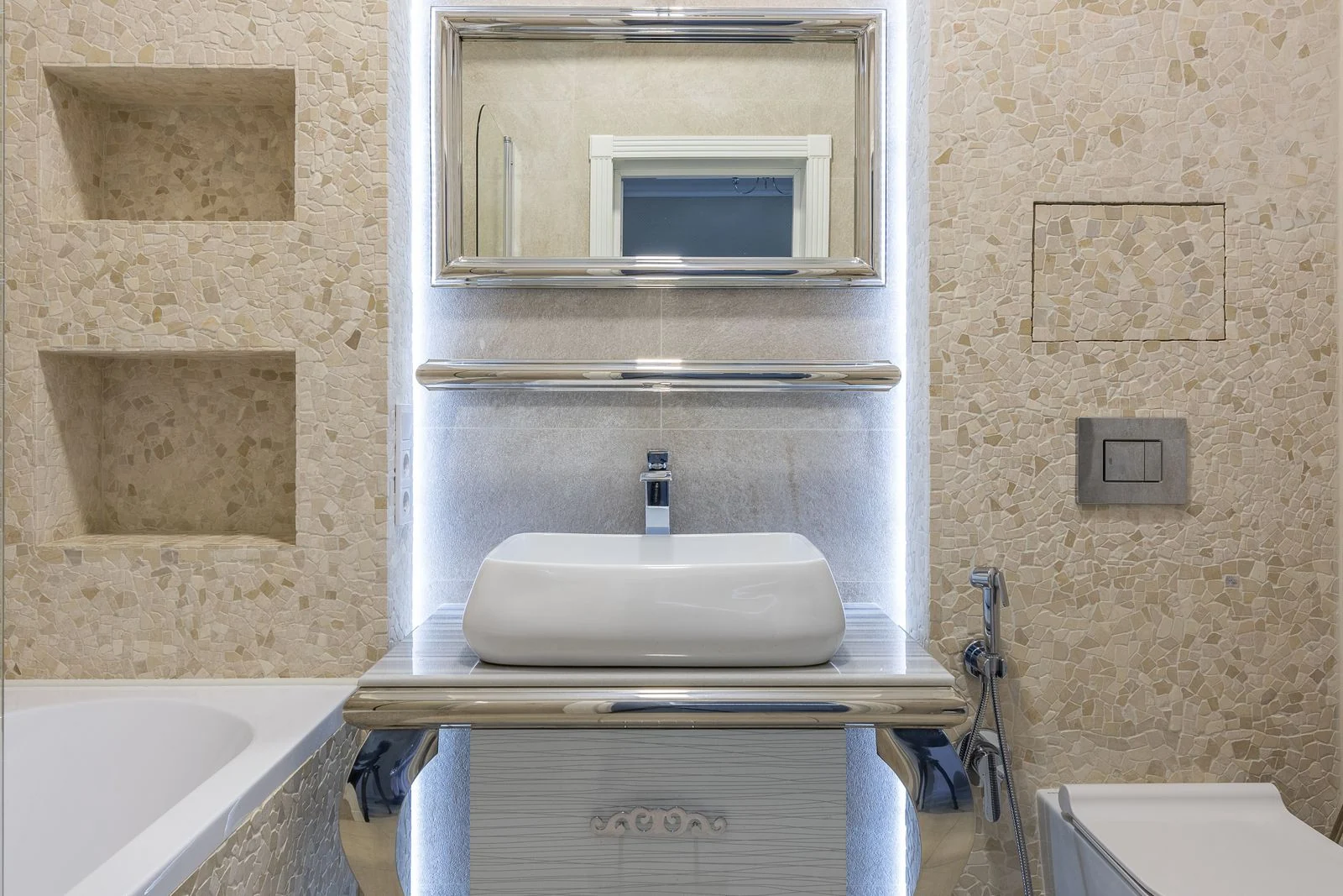 Modern bathroom interior with washstand under rectangular shaped mirror between bath and toilet bowl at home