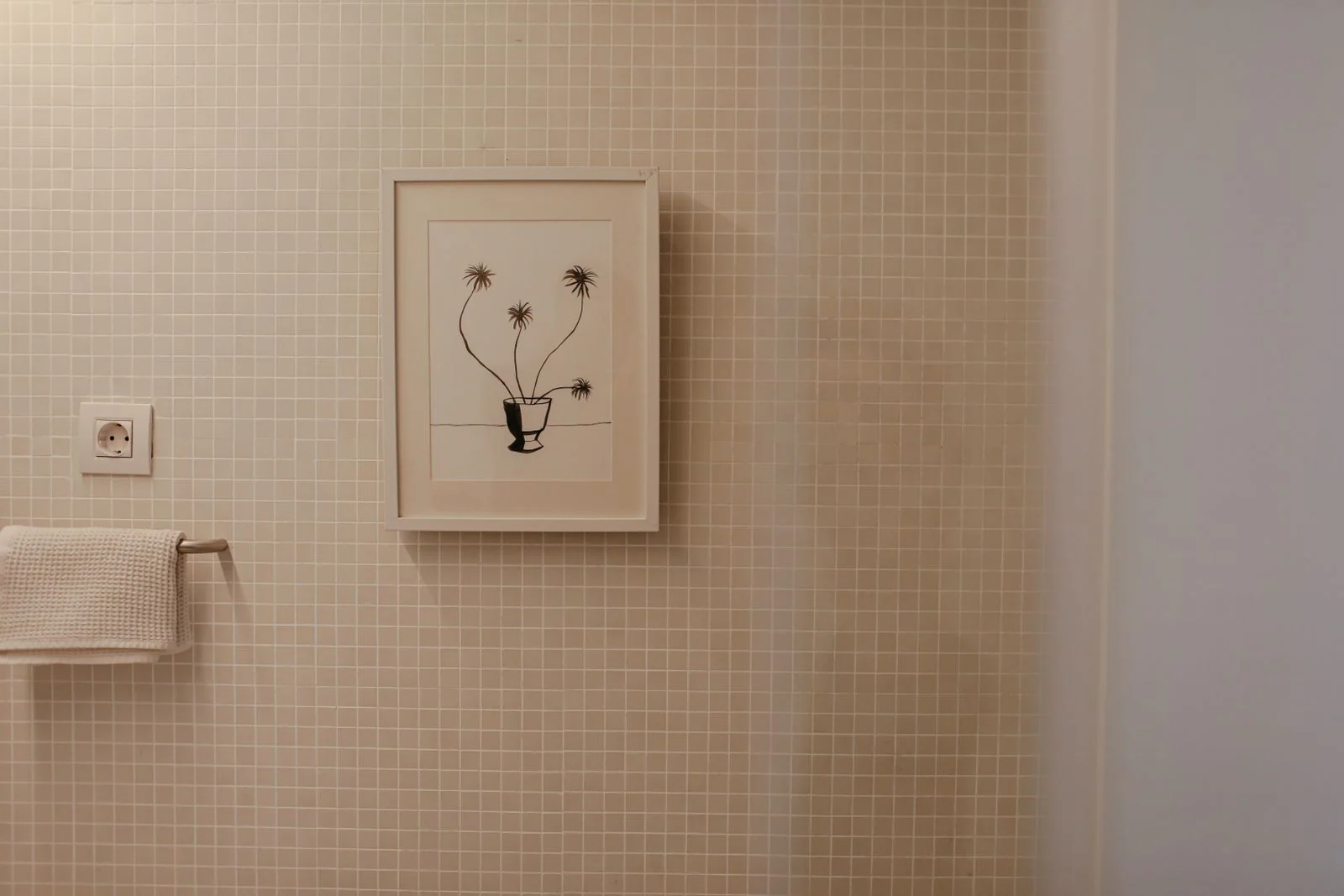 A modern bathroom featuring a framed plant illustration on tiled wall, perfect for interior inspiration