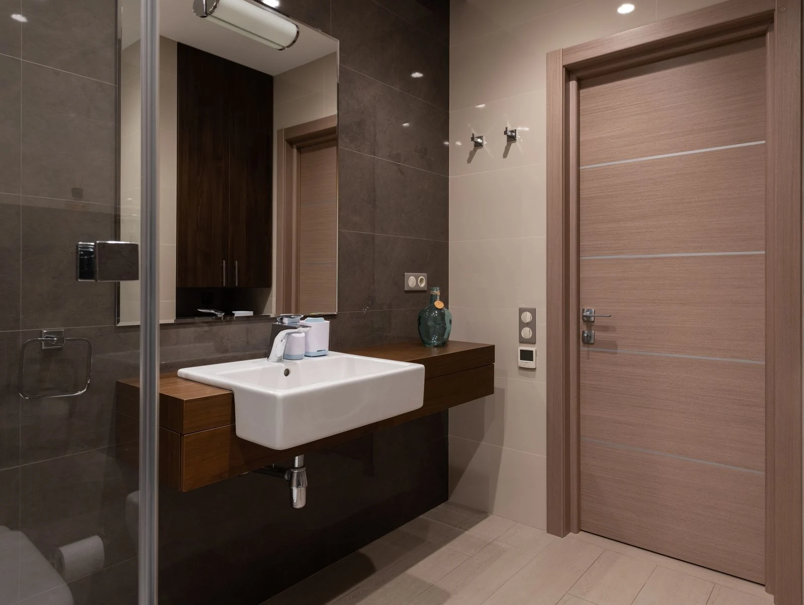 Sleek bathroom interior with a modern sink, mirror, and wooden door. Minimalist design focus